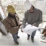 Two contractors reading blueprints