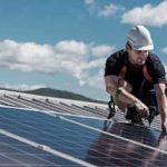 worker installing solar panels